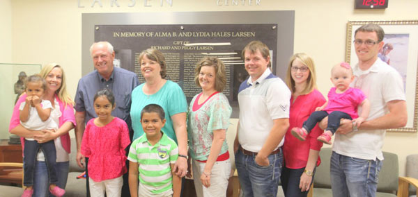 Larson family standing in front of the Alma and Lydia Larsen Memorial